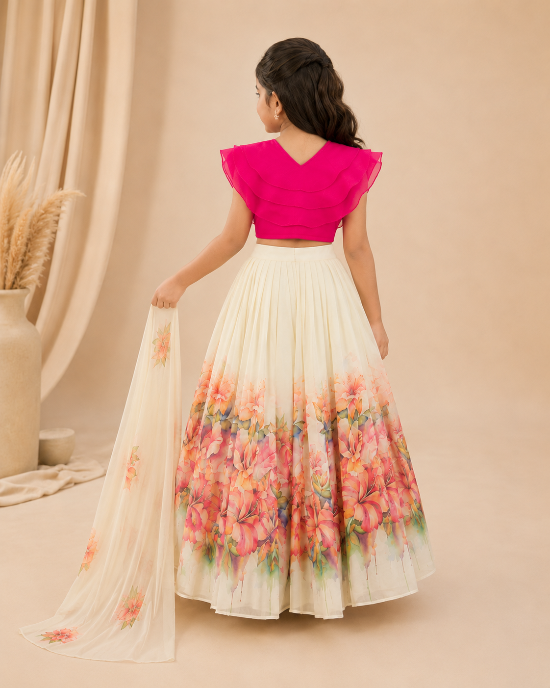 Woman wearing a pink top and floral skirt against a beige background