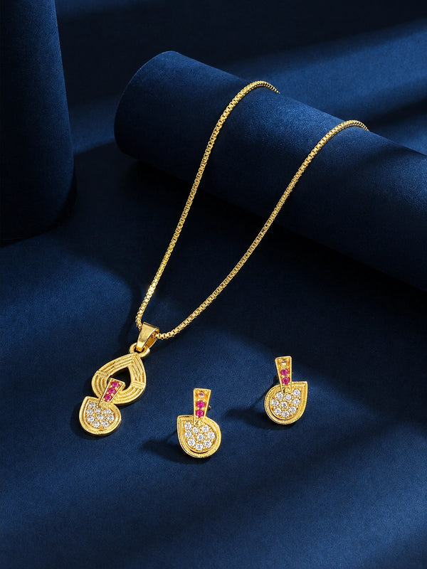 Gold pendant necklace and matching earrings with a teardrop-shaped pendant featuring small pink stones and clear rhinestones, displayed on a dark blue velvet surface.