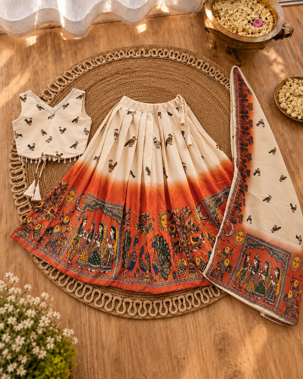 Girl wearing a cream and orange girls lehenga choli set
