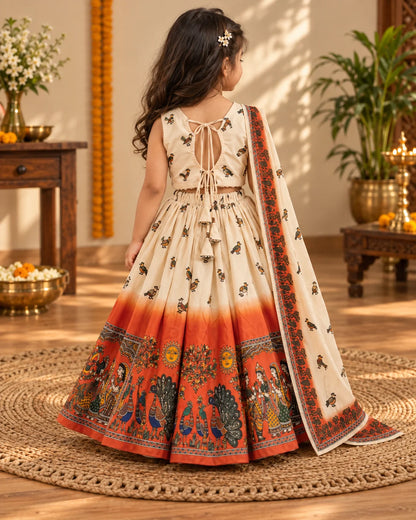 Girl wearing a cream and orange printed lehenga choli set with dupatta