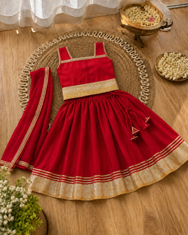 Red traditional outfit with gold accents on a wooden surface