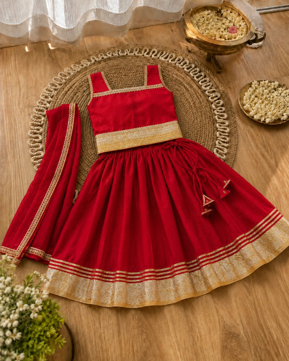 Red traditional outfit with gold accents on a wooden surface